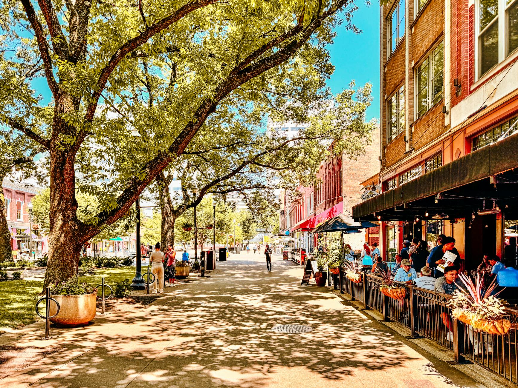 A scenic view of historic brick buildings along Main Street in Reisterstown, Maryland, framed by mature green trees.