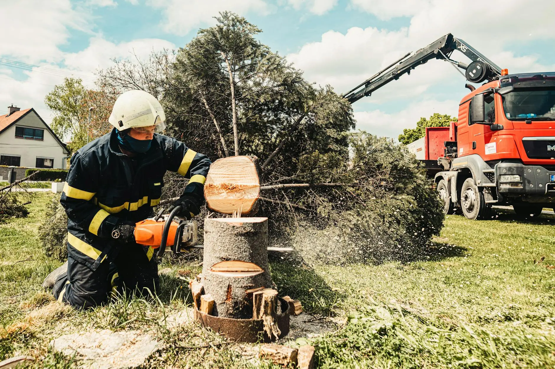 A tree service professional using a wood chipper to process branches on a residential street in Towson.